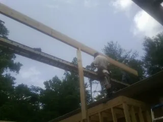 Carpenter setting a ridge beam over a new addition frame — Ice Dam Removal by Roofing Brothers in Seibert