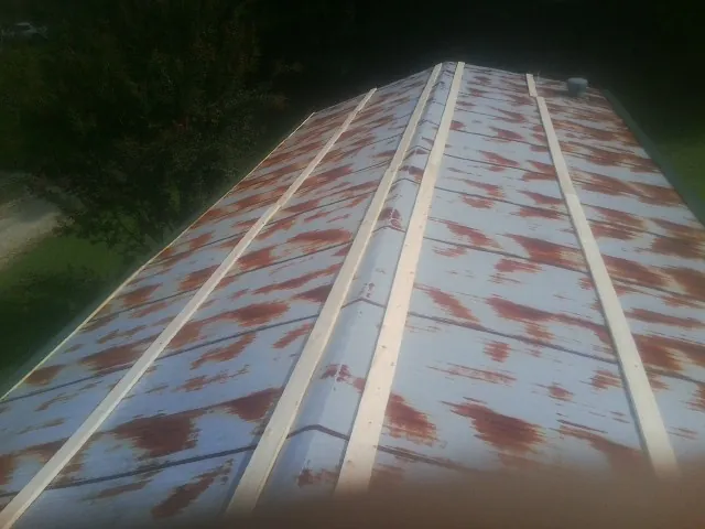 Rusted metal roof panels with new wood purlins before replacement — Storm Damage Roof Repair in Seibert by Roofing Brothers