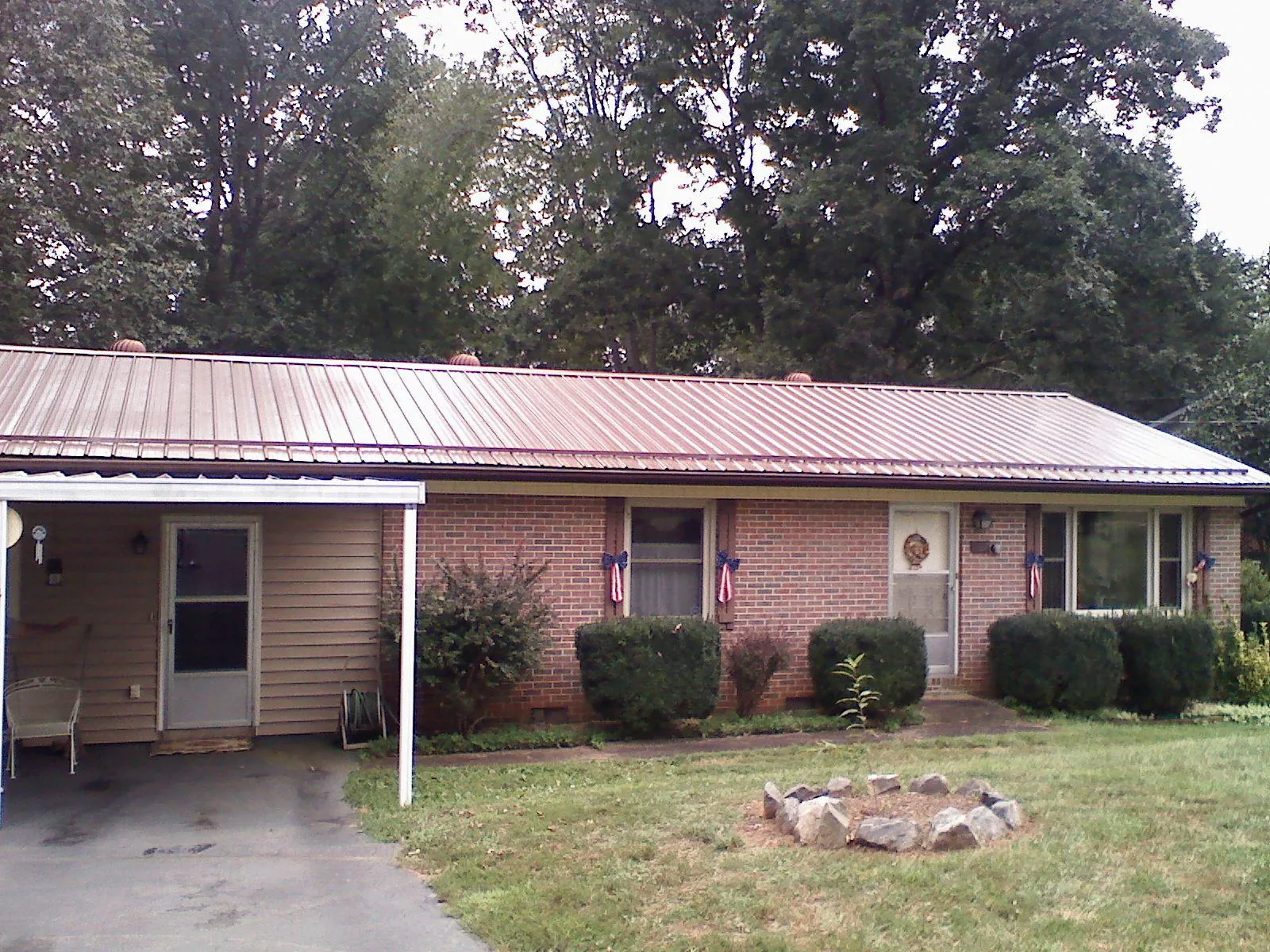 Bronze metal roof and carport on a brick ranch home — Roof Repair work by our crew in Seibert